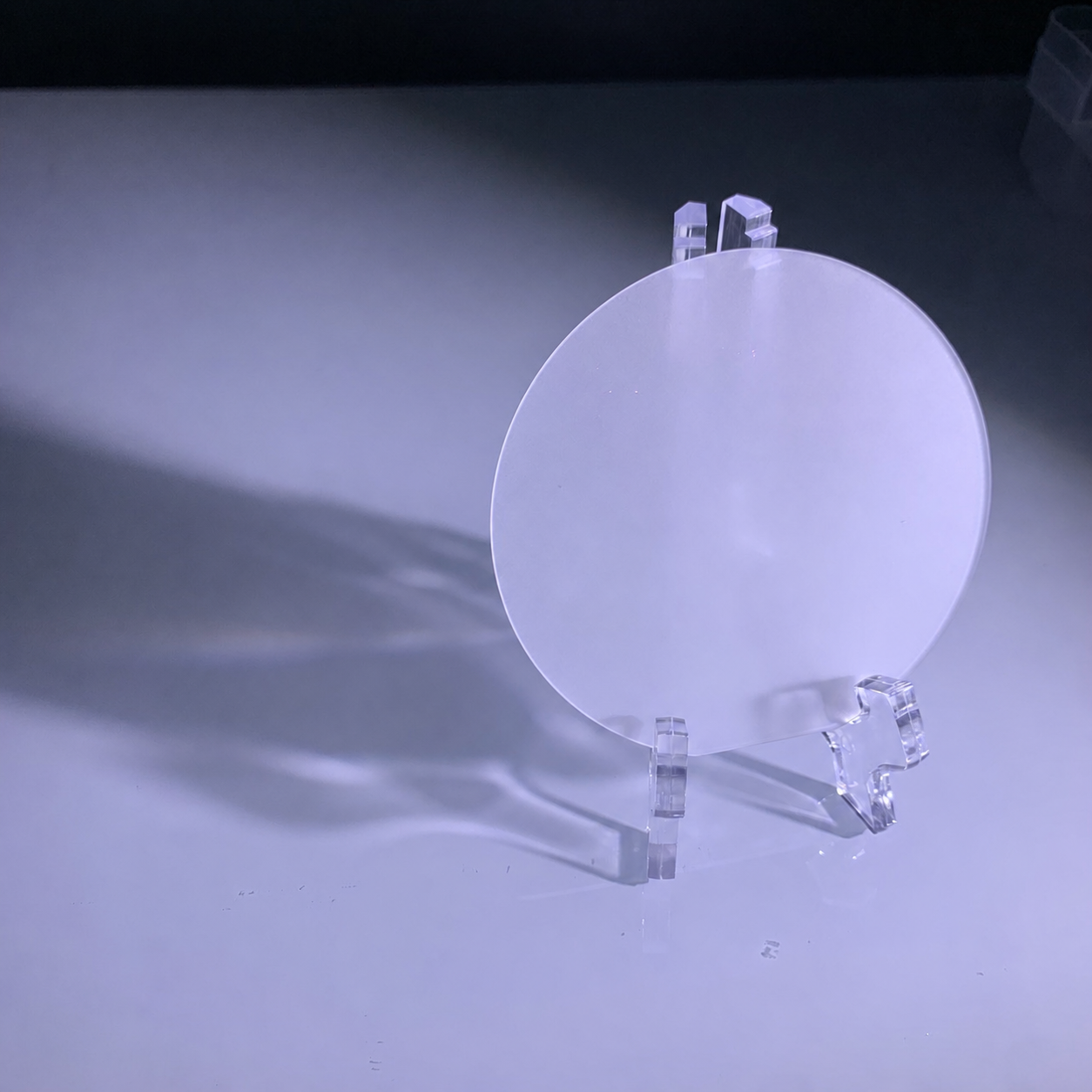 Polished sapphire wafer on a clear studio stand